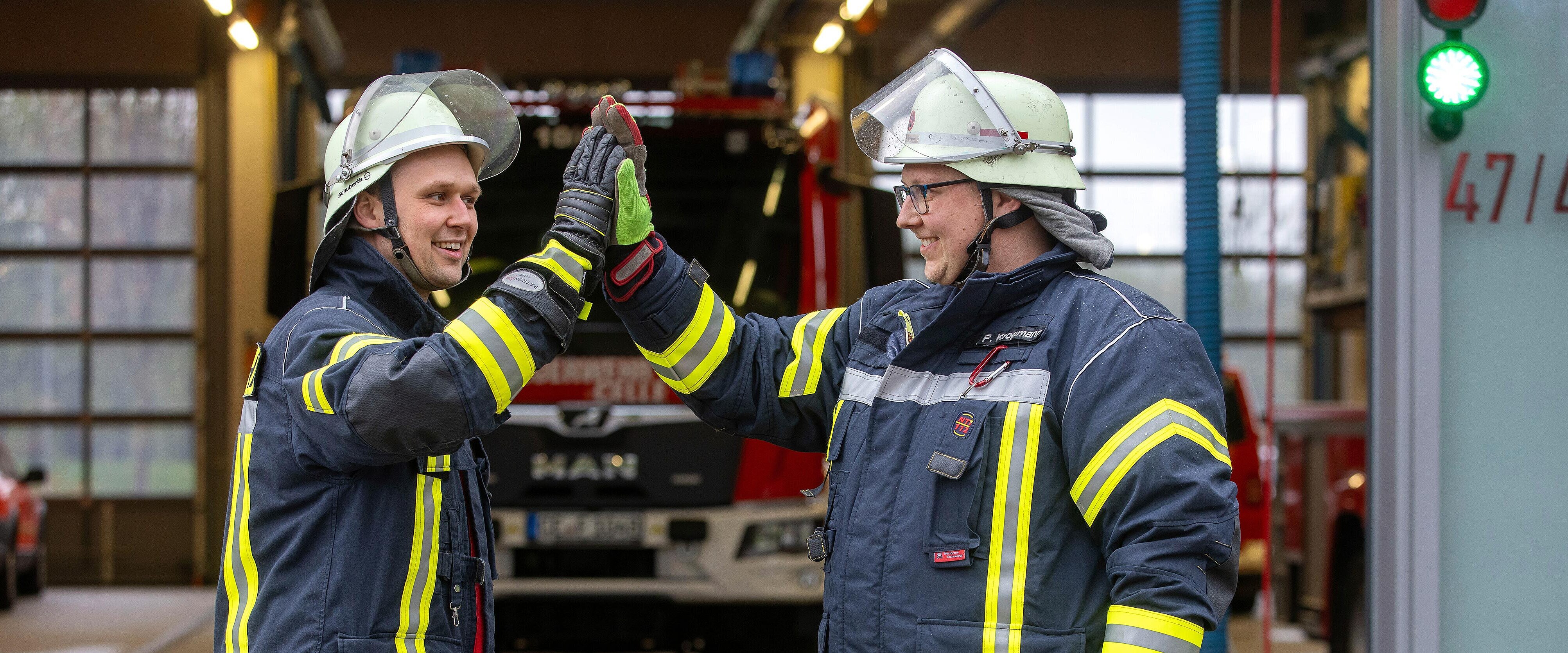 Zwei Feuerwehrleute geben sich Highfive.