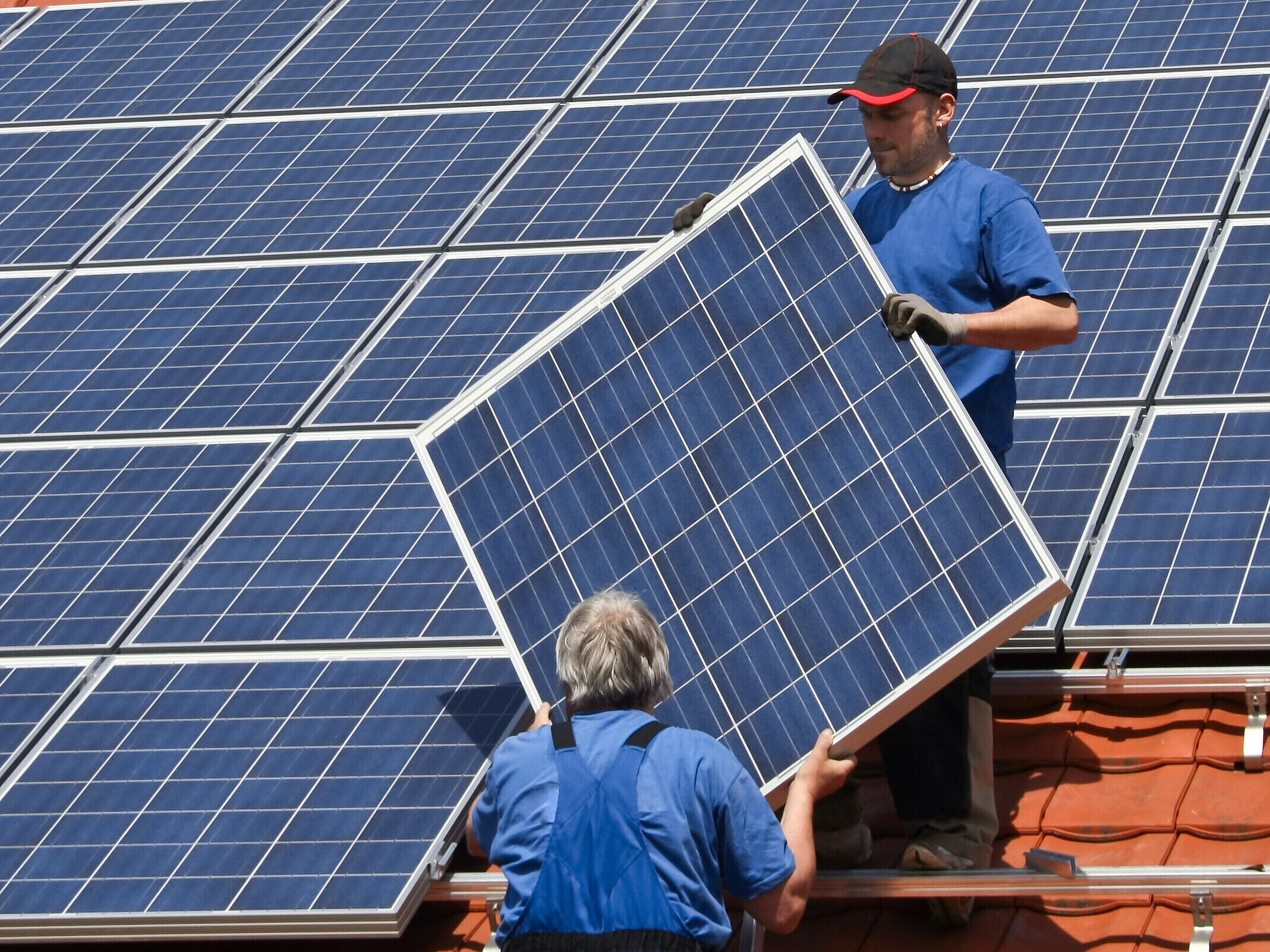 Installation einer PV-Anlage auf einem Dach eines Hauses.
