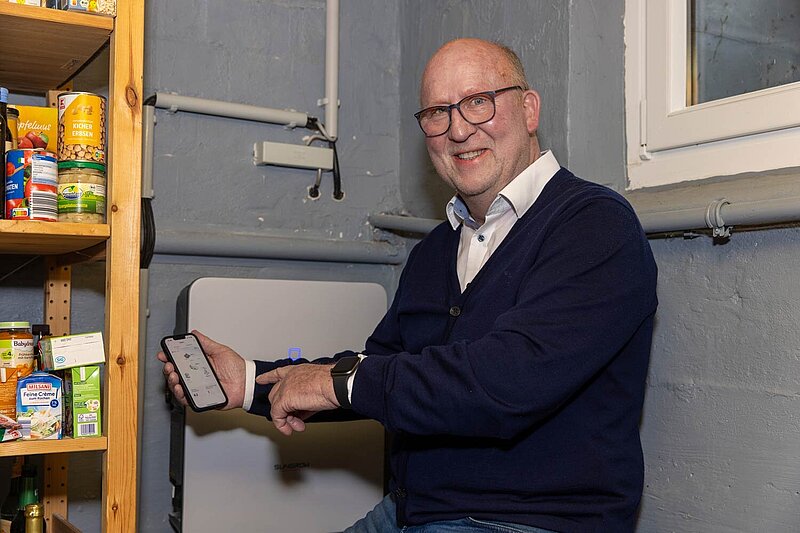 Das Foto zeigt Wolfgang Haase mit seinem Smartphone im Heizungskeller. 