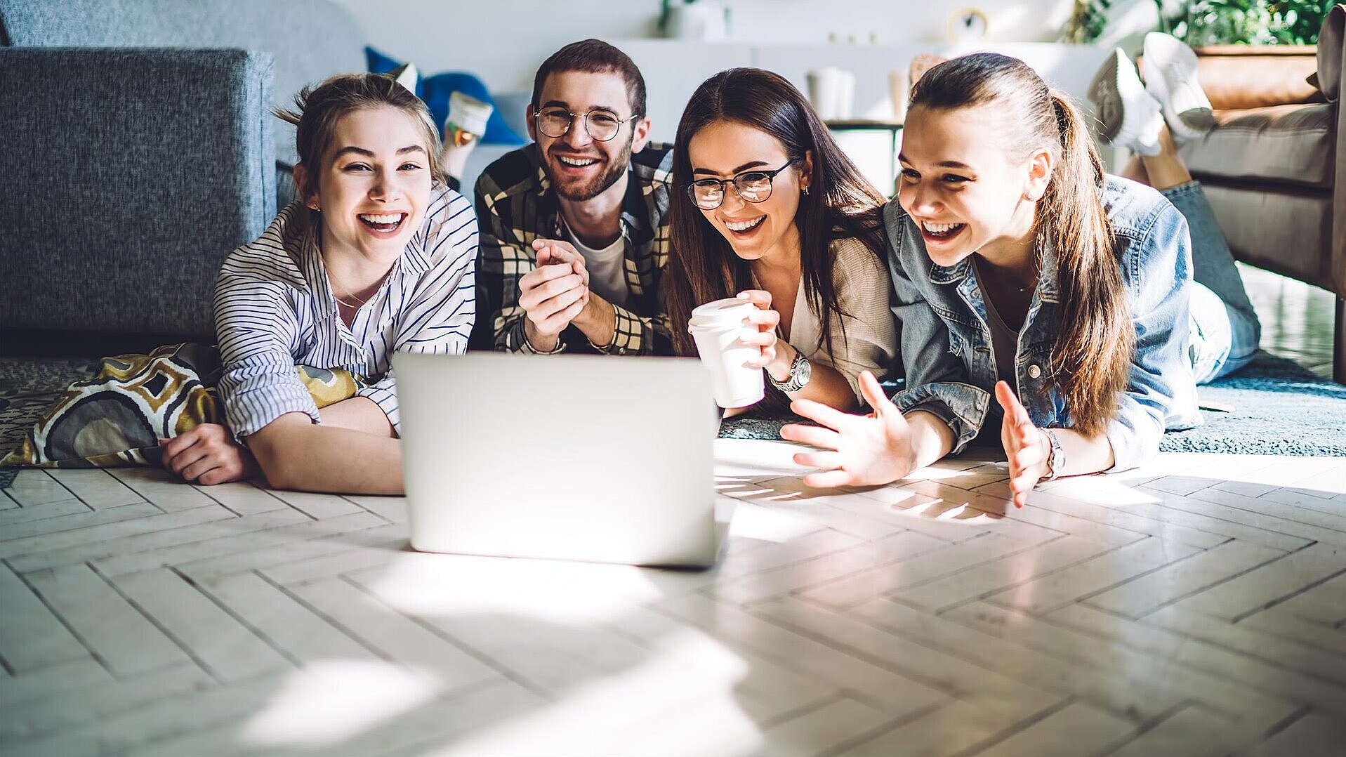 Vier Freunde am Laptop Ein Mann und drei Frauen schauen gemeinsam auf einen Laptop.